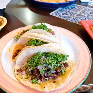 three tacos on a plate on a table