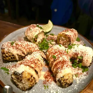 ELOTE Roasted corn on cob with lime, mayo, epazote, serrano, cotija, chili powder