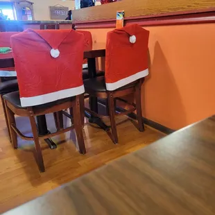 two santa hats on the back of the chairs