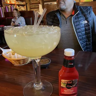 a man sitting at a table with a margarita in front of him