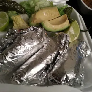 Three shrimp tacos packed to go with avocado!