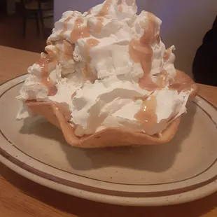 a dessert with whipped cream and caramel sauce