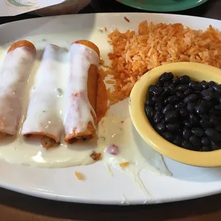 Chicken fajita enchiladas, corn tortillas, rice and steamed beans.