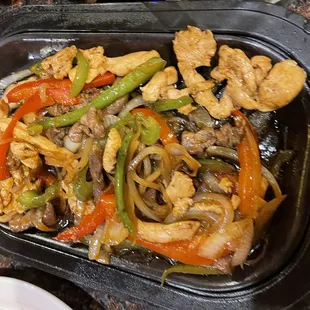 a plate of chicken, peppers, and onions