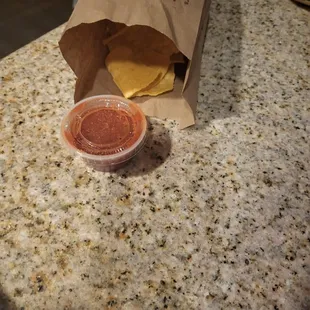 a paper bag on a counter with a sauce in it