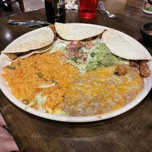 Fish tacos also with a generous side of guacamole, rice and beans.