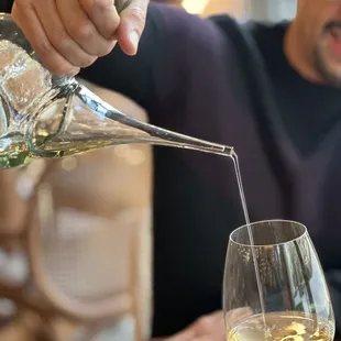 a man pouring a glass of white wine