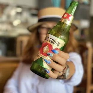 a woman holding a bottle of beer