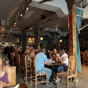 a large group of people sitting at tables in a restaurant