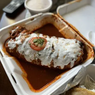 Birria wet burrito with red sauce combination (beans and rice on the side)