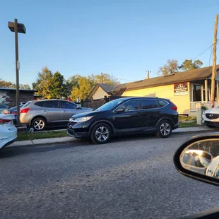Cars parked ON THE SIDEWALK.