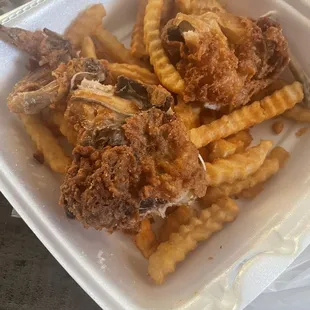 fried chicken and fries in a styrofoam container