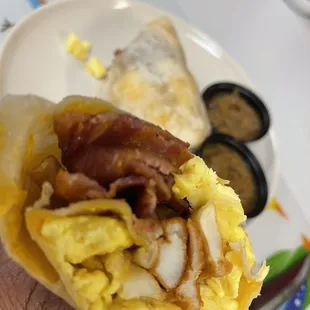 a hand holding a breakfast burrito