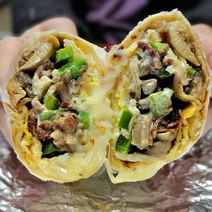 Breakfast Burrito with eggs, cheese, bacon, grilled onions, green peppers, mushrooms, and ranch dressing.