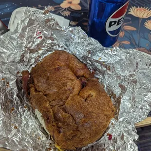 Bacon egg cheese on croissant. Pepsi