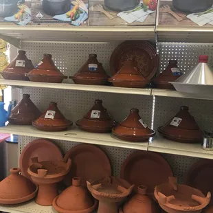a shelf of clay pots and pans