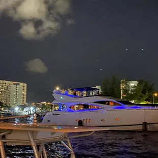 a yacht docked in a harbor at night