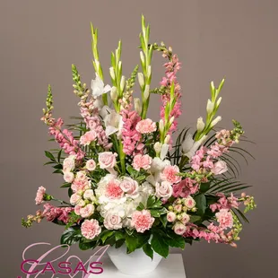 Pastel pinks with roses, snapdragons, carnations and accents of white hydrangea and gladiolas