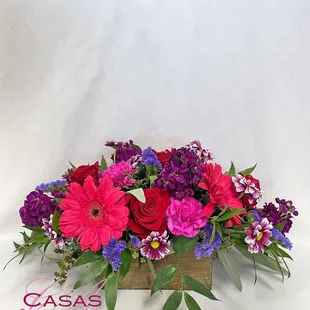 Roses, gerbera daisies, stock and more in a berry colored palette.