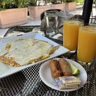 a plate of food and two glasses of orange juice