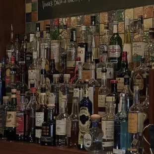 a wall of liquor bottles on a bar