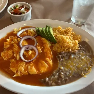 Huevos Ranchers with the eggs scrambled in butter, rice and refried beans. Delish!
