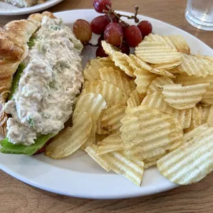 Yummy Chicken salad croissant sandwich, grapes, and chips!