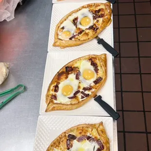 a row of flatbread pizzas