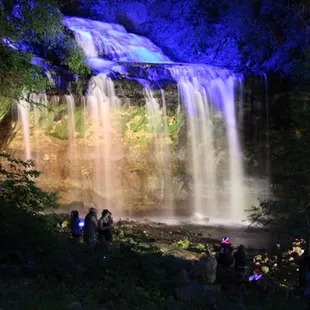 Cascade Falls illuminated at night .