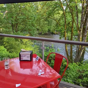 a red table and chairs overlooking a river