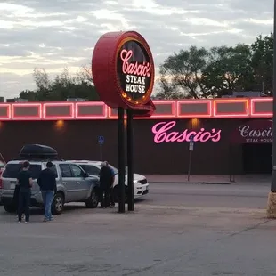 Outside neon signs at dusk