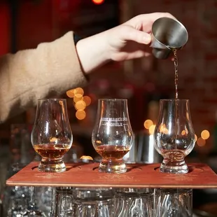 a person pouring wine into glasses
