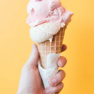 a hand holding an ice cream cone