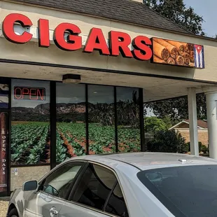 a car parked in front of a cigar shop
