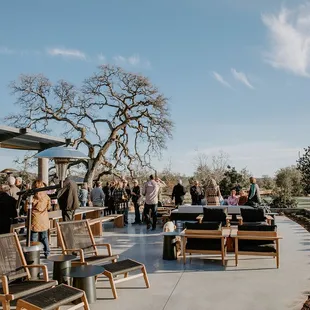 a crowd of people standing and sitting outside