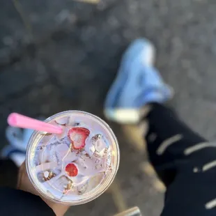 a person sitting on a bench with a drink in their hand