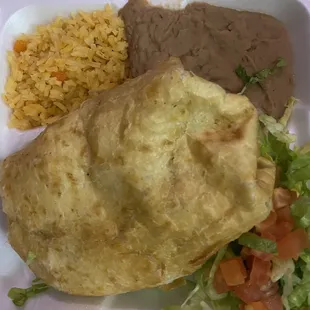 Chimichanga plate with flavored rice and refried beans and fresh lettuce and tomatoes toppings that I rolled inside
