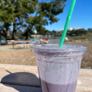 a purple drink with a green straw