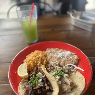 Two taco combination with Al pastor and carnitas. Cucumber chía agua fresca in the background.