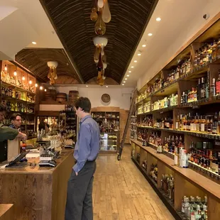 a man standing at a counter in a liquor store