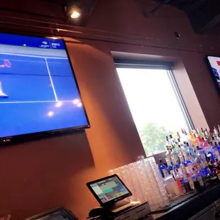 a man playing tennis on a large screen tv