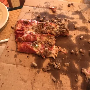 The left over of a pepperoni and sausage pizza