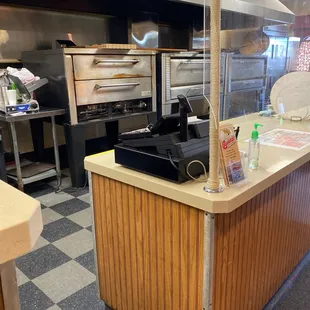 a counter with a pizza oven in the background