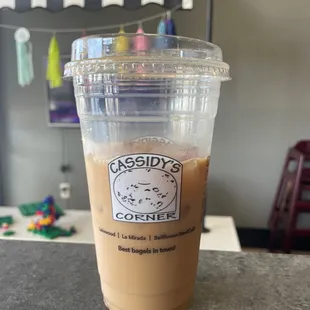 Black iced coffee that I add milk and honey to. Play area in the background.