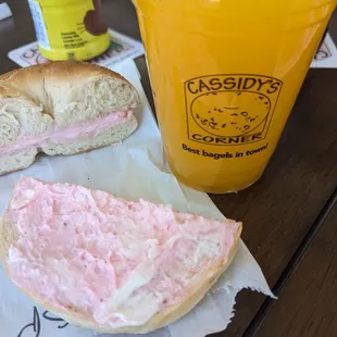 Plain bagel with strawberry cream cheese and fresh pressed orange juice