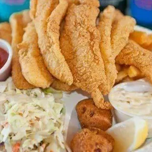 a plate of fried fish, fries, coleslaw, coleslaw, coleslaw slaw,