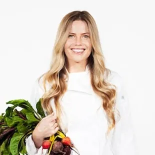 a woman holding a bunch of vegetables