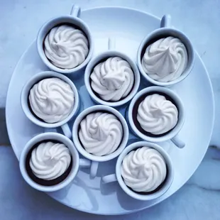 six cups of whipped cream on a white plate