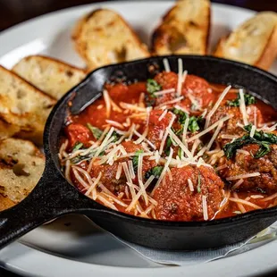 a skillet of meatballs and bread