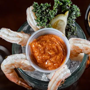 a bowl of shrimp and a glass of wine